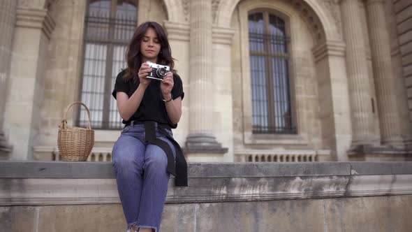 Beautiful Young Woman with Dark Hair Wearing Jeans and Black Tshirt Is Taking Pictures of the City