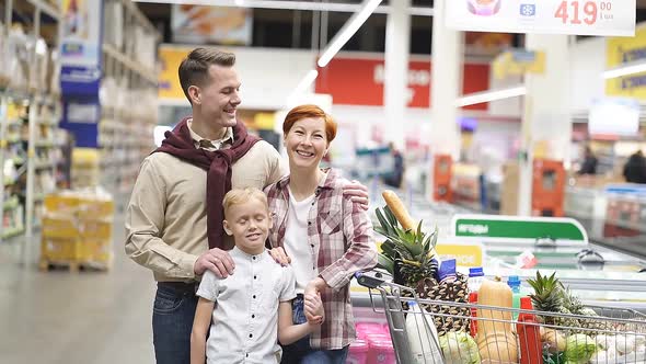 Caucasian Family Buying Healthy Food Products in Grocery Store Posing at Camera