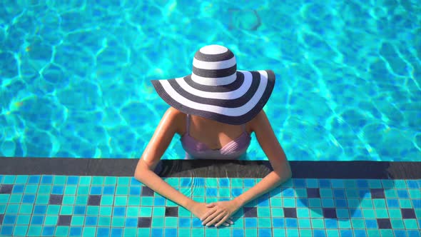 Young asian woman enjoy around outdoor swimming pool for leisure alt