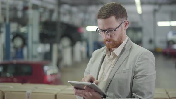 Young Confident Caucasian Salesman Using Tablet, Looking at Camera and Gesturing Yes By Shaking Head alt