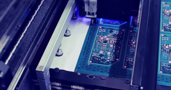 Closeup Circuit Board in Automatic Equipment on Conveyor Line with Blue Light