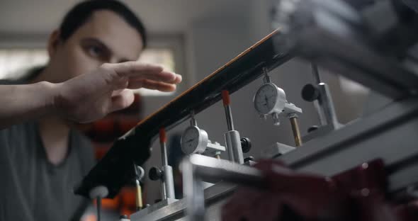 Luthier Brushes Off the Wood Dust From Sanded Guitar Neck Works at the Musical Instruments Repairing alt