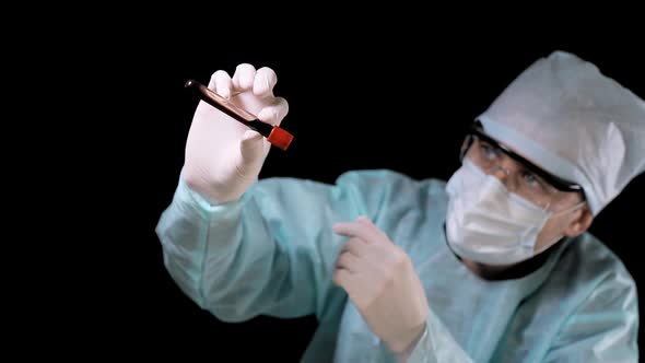 Medical Doctor Performs a Blood Test. The Technician Holds a Tube with a Blood Test in His Hand and alt