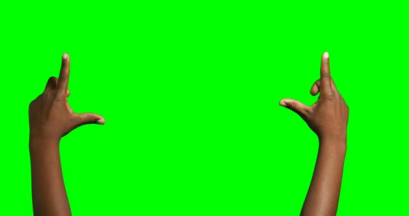Person making hand gesture against green screen background alt