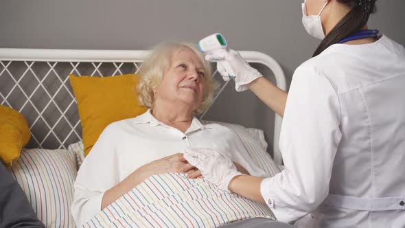 Young Nurse Take Care Senior Woman on Bed Nurse Checking Temperature
