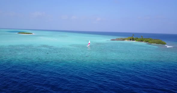 Beautiful above clean view of a white sandy paradise beach and blue ocean background in vibrant  alt