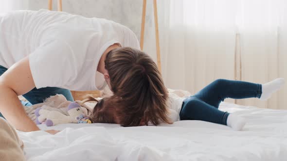 Loving Young Father Caucasian Dad Playing Game with Baby at Home Lying on Bed Tickling Child alt