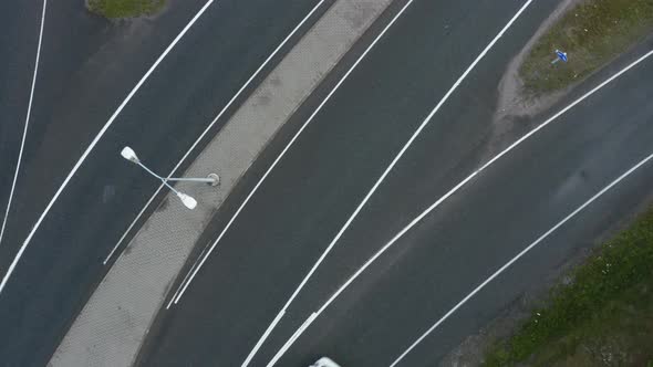 Slow top down aerial pan of fasting vehicles entering a motorway in Finland near Helsinki. alt