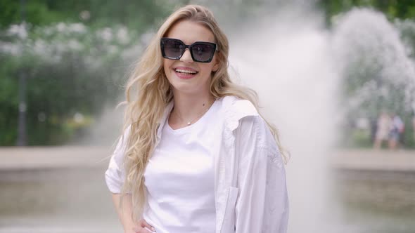Smiling Woman in Sunglasses in Park