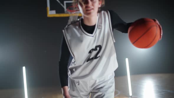 Slow Motion Portrait of Cheerful Sporty Woman Basketball Player Hits the Ball Off the Floor alt