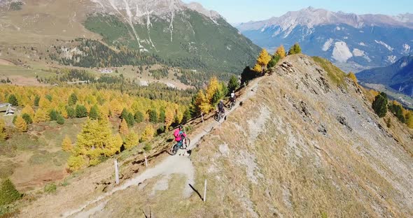 Aerial drone view of a group of mountain bikers on a singletrack trail. alt