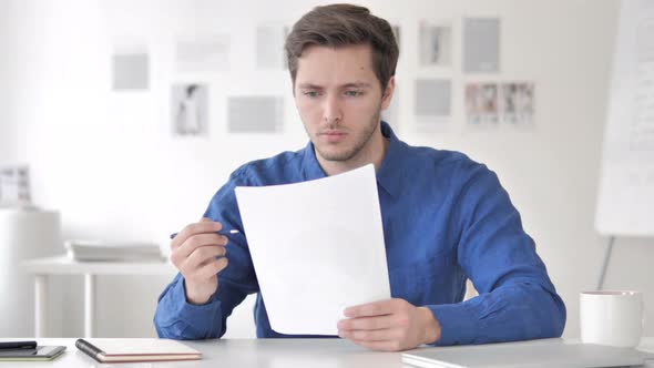 Casual Adult Man Reading Documents in Office alt