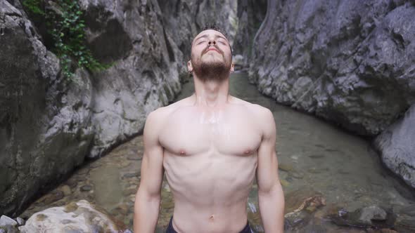 Sporty young man in creek in canyon. alt