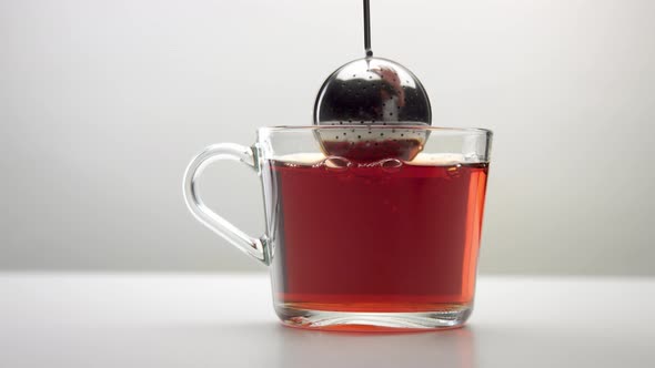 Slow Motion of an Intensive Movement of the Infuser Spoon with Tea in Cup