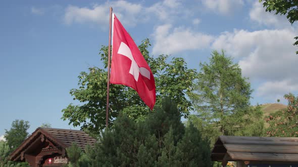 Swiss National Flag Above the Farmhouse in the Alpine Mountains. alt