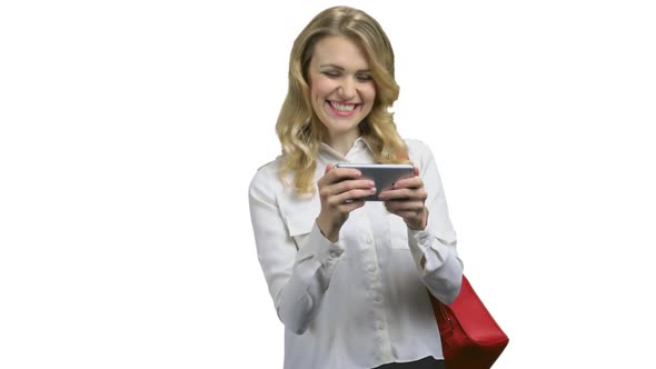 Emotional Young Woman Playing Mobile Game on White Background alt