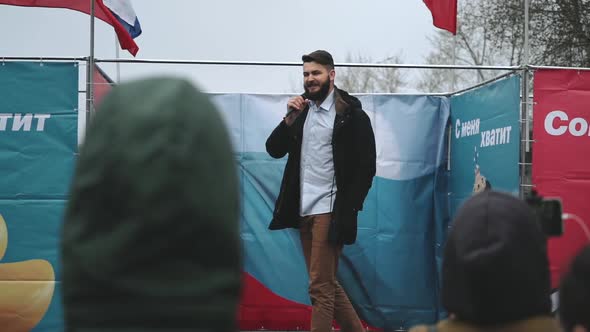 Protester Speaker with Microphone Gives Speech to Rally Crowd with Russian Flags