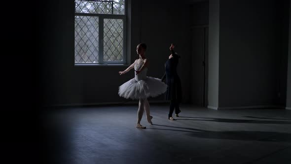 Wide Shot Slim Female Ballet Dancers in White and Black Bending Standing in Fourth Position in alt