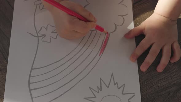 Unrecognizable Baby Child Hands Coloring Rainbow on White Sheet Paper Crayons alt