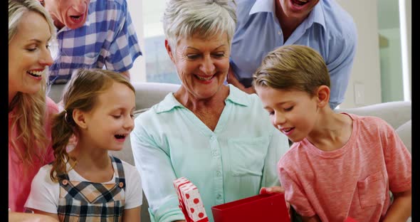 Multi-generation family sitting together in living room alt
