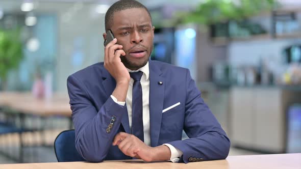 Cheerful African Businessman Talking on Phone in Office alt