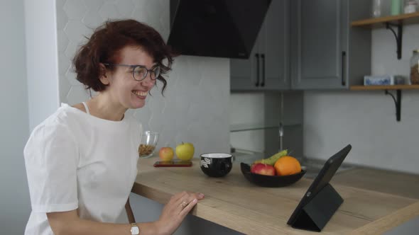 Woman Sitting at Home on Lockdown Online Chatting Talking to Webcam on Digital Tablet and Smiling