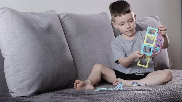 A little boy gaming with magnetic constructor. Creativity development. Magnetic constructor. alt