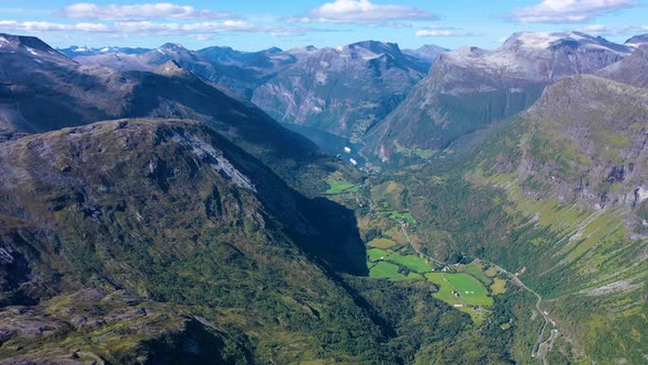 Breath taking view of mountain peaks and green valley and a lake in geiranger fjord in Norway alt