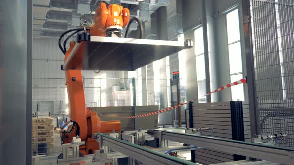 Automated Robotic Arm Works in a Factory Floor. alt