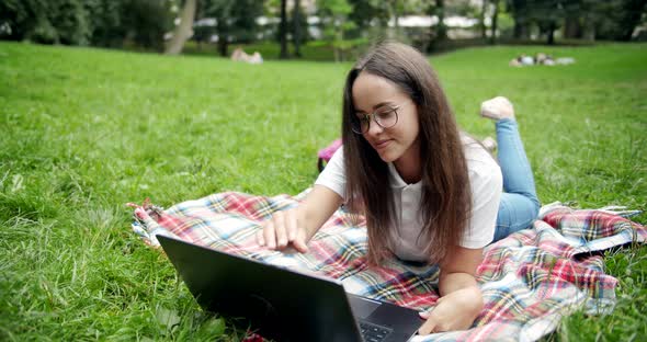 Woman Lying on Lawn with Laptop