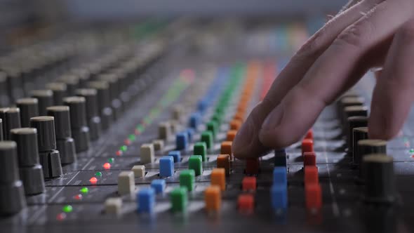 Record Producer Adjusting Sound on Audio Console alt
