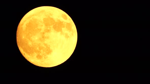 Glowing Yellow Huge Full Moon As Seen From Earth Through the Clouds Against Starry Night Sky alt