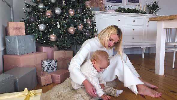 Mother's Christmas Mood with Her Child, Near the New Year Tree. Winter Holidays. alt