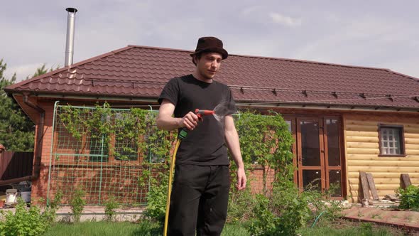 Man Watering Beautiful Green Lawn alt