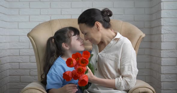 Mother and daughter hold tulips.  alt