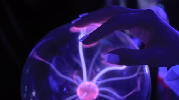 Woman Hand Touching Plasma Ball with Many Energy Rays Inside  Close Up