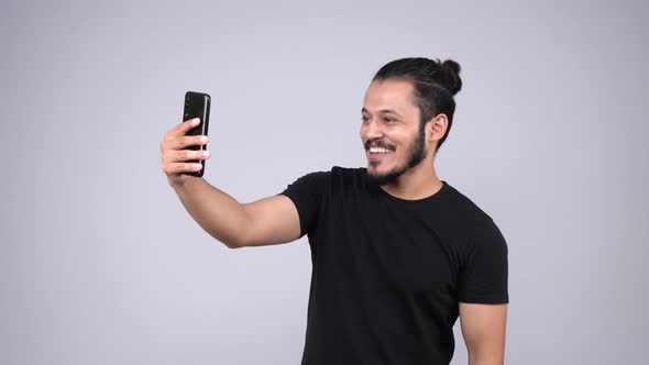 Happy young Indian man doing a video call alt