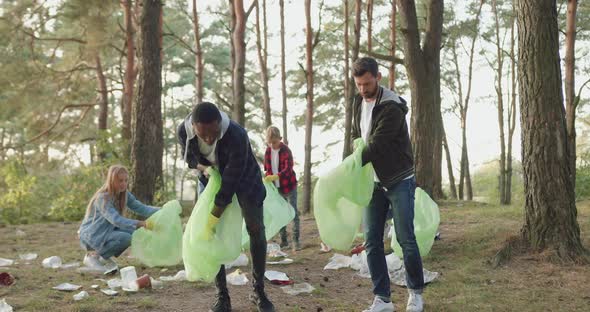 Men Helping to Collect Rubbish Into Plastic Bags their Friends-Nature Activists and Giving High Five alt