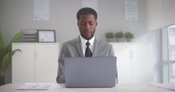 Young Afroamerican Employee Working on Laptop During Working Day in Office alt