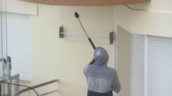 A Man Uses a Highpressure Machine to Disinfect the Walls of a Multistorey Building for Subsequent alt