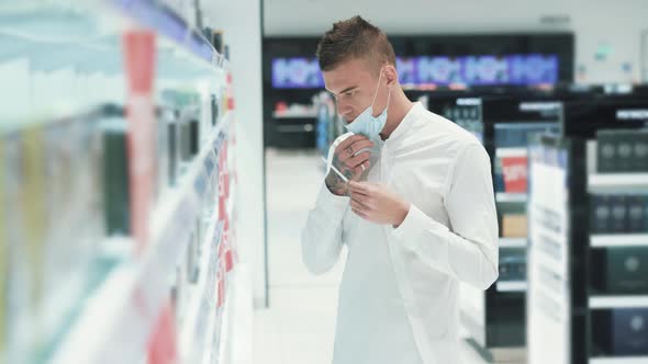 Caucasian Slim Young Man in Medical Mask Testing New Fragrances alt