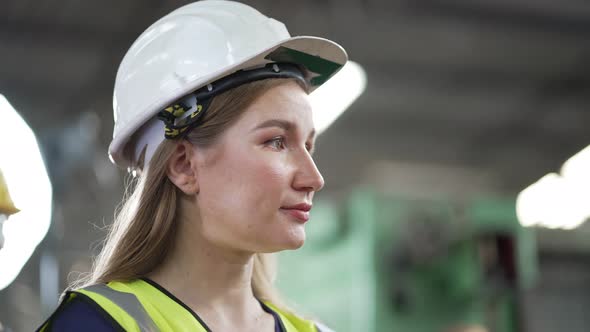 Female engineer worker in safety hardhat smiling and looking at camera