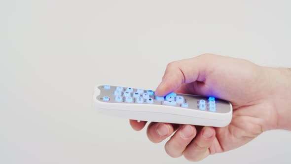 Hand pressing the remote control buttons alt