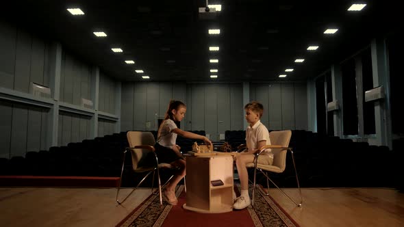 Child prodigies sit at a table at a game of chess. Proffesional shooting