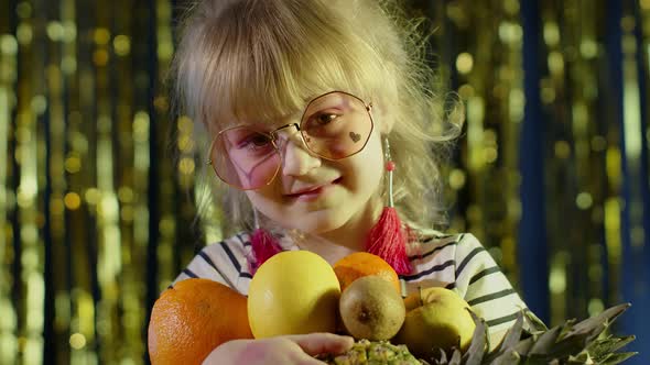 Closeup Shot of Girl in Stylish Sunglasses Posing Looking at Camera with Bunch of Fruits in Hands alt