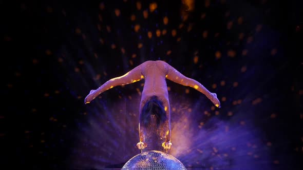 The Gymnast Performs an Acrobatic Number on a Mirror Ball