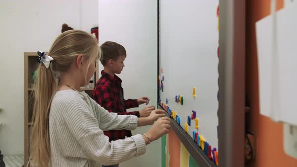 Children Pupils Learn English By Making Words From Letters on a Magnetic Board alt