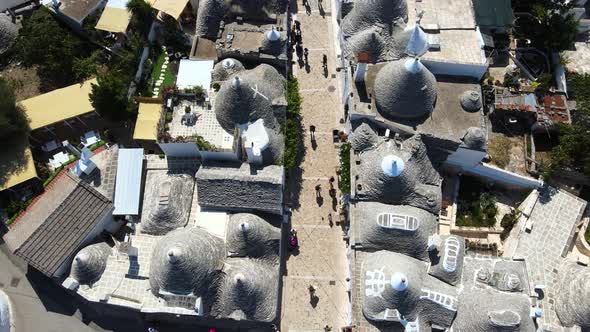 Aerial drone top shot of small walking streets around Alberobello, Italy. whitewashed stone huts wit alt