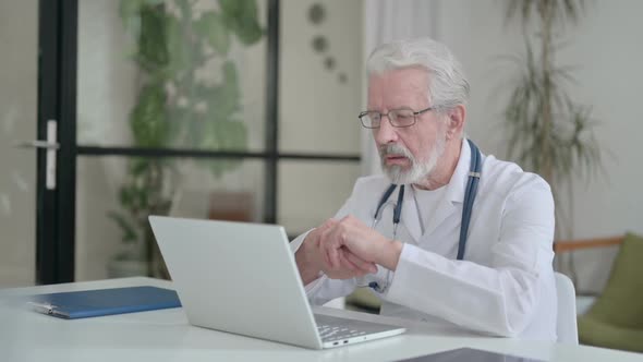 Senior Old Doctor Talking on Video Call on Laptop in Clinic alt