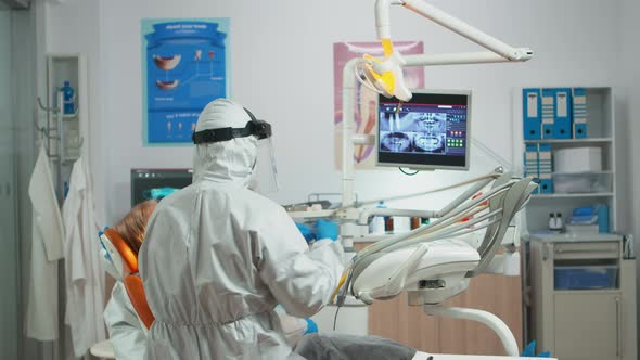 Dentist with Face Shield Working in Dental Unit During Covid-19 alt